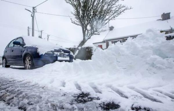 Council workers clear snow drifts on a laneway near Glencullen in the Dublin Mountains where cars and some homes were snowed in for a time following heavy snowfall Thursday. Picture: Damien Storan.