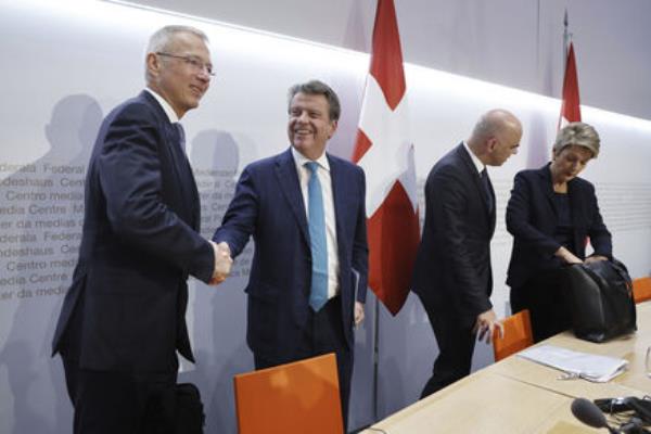 Axel Lehmann, Chairman Credit Suisse, left, and Colm Kelleher, Chairman UBS, shake hands beside Swiss Federal President Alain Berset and Swiss Finance Minister Karin Keller-Sutter. Photo credit: Peter Klaunzer/Keystone via AP